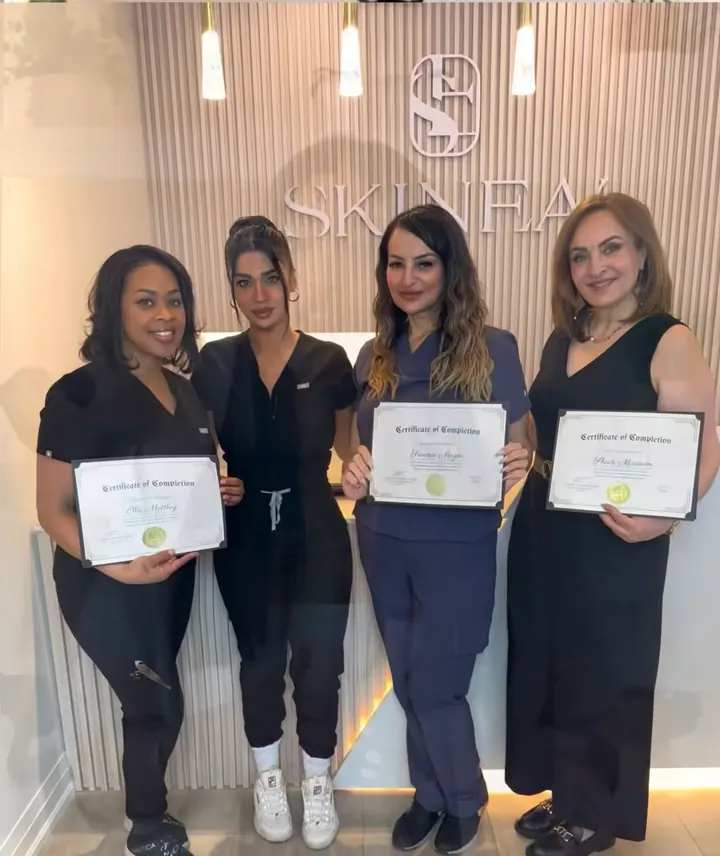 Four SKINEAV Academy graduates smiling with their certificates in the Vaughan clinic